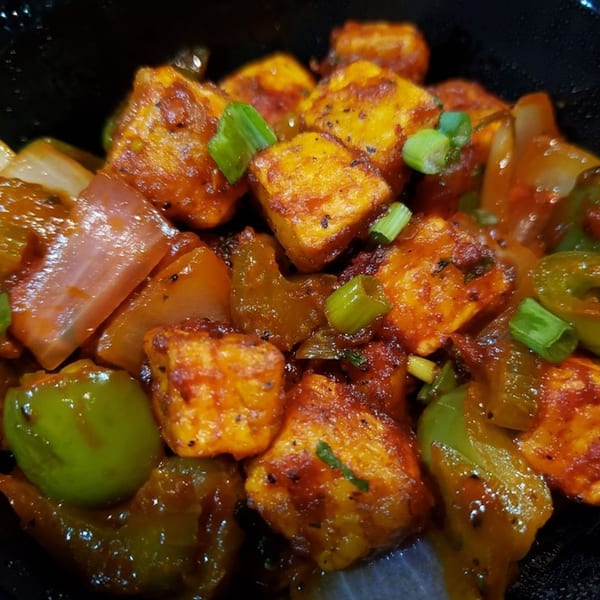 Close-up of Chettinadu Indian Cuisine's chili paneer with bell peppers, onions, and green onions.